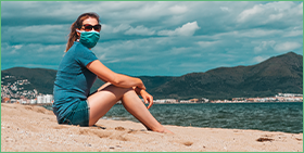 Germany Corporate Payment Survey 2021: Learning to live with the pandemic. The image is a photo of a woman wearing a facemask and sunglasses, sitting on a beach.